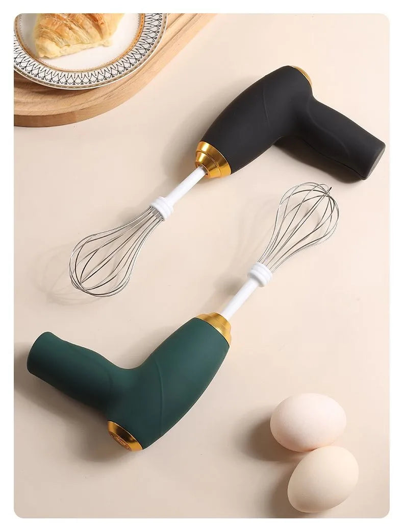 Two whisks with black and green handles on a beige surface with eggs and bread in the background.